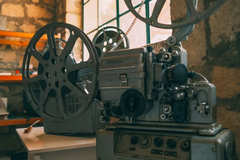 An old film projector with two reels mounted on a table.