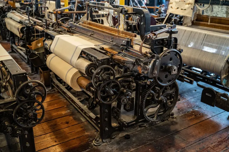 Old mechanical looms in a textile factory hall.