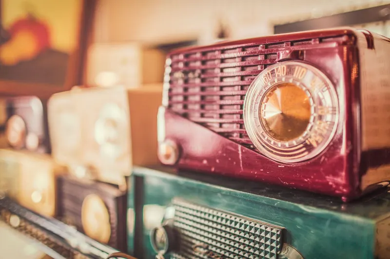 An old tabletop radio in a wine-red case with a circular tuning dial.