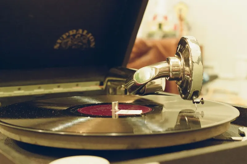 An old record player with a metal horn and a disc spinning on the turntable.